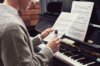 Man holding RELX Artisan Device playing piano